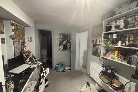 Well-appointed bedroom with a study area, shelv...