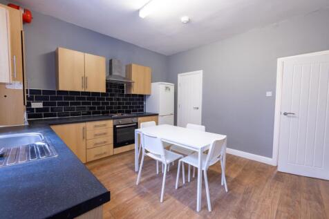 Bright modern kitchen with light wood cabinets,...