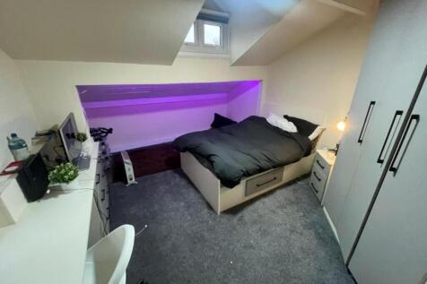 A spacious, well-lit master bedroom featuring a...