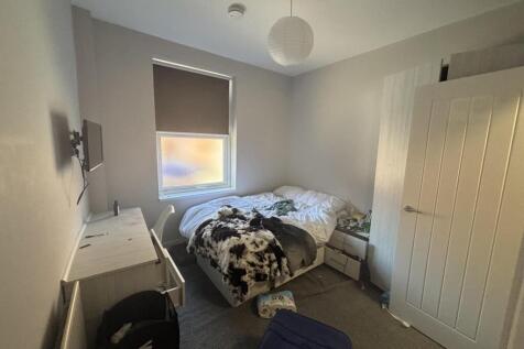 A spacious master bedroom featuring a large bed...