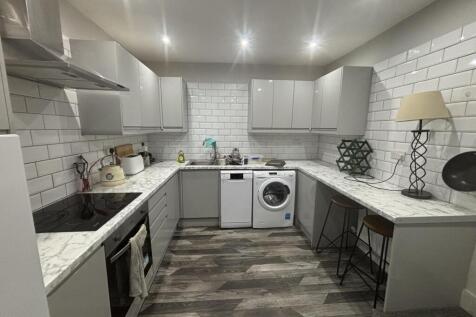 A clean and modern kitchen with ample counter s...