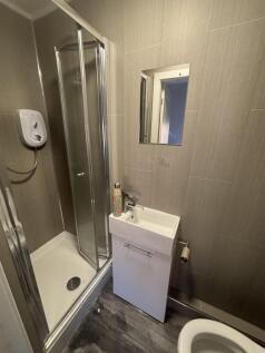 A modern, clean bathroom with a small shower un...