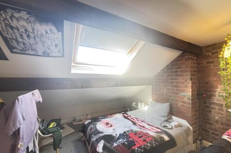 A cozy bedroom with a skylight window allowing ...