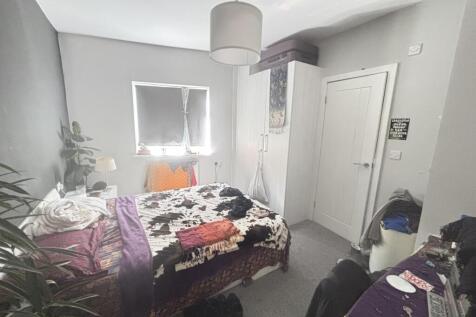 A cozy bedroom featuring a double bed with colo...