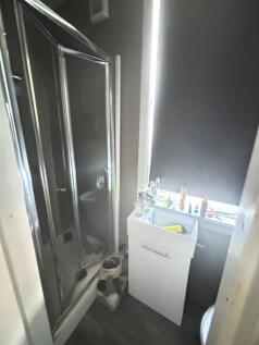 A functional bathroom with a shower unit and a ...