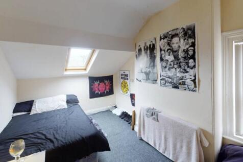 A well-lit, tidy bedroom with a comfortable dou...