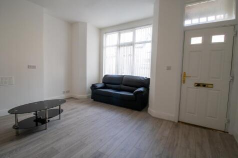 A bright, spacious living room featuring a comf...