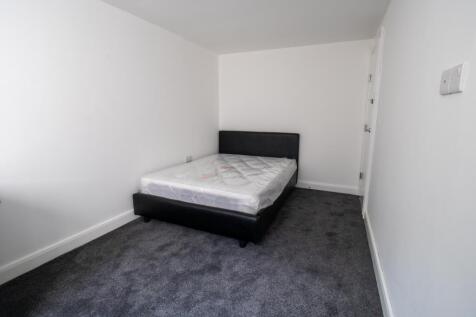 A tidy and simple bedroom featuring a double be...