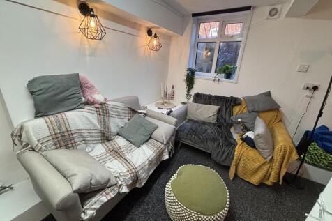 A cozy and well-lit living room featuring comfo...