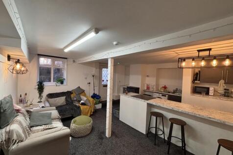 A spacious, well-lit living room featuring comf...