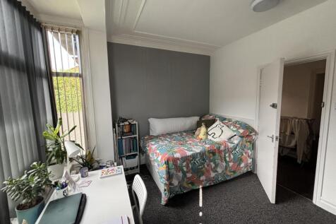 A cozy bedroom featuring a bed with colorful be...