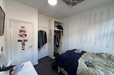 A cozy bedroom featuring a neatly made bed and ...