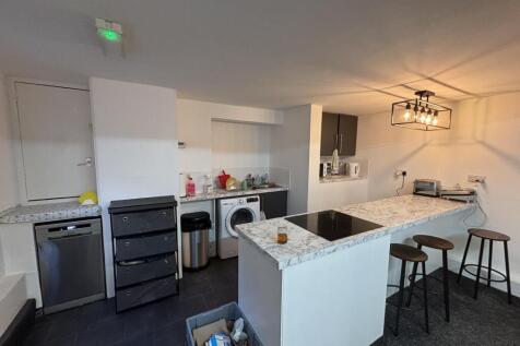 Contemporary kitchen area with a white countert...