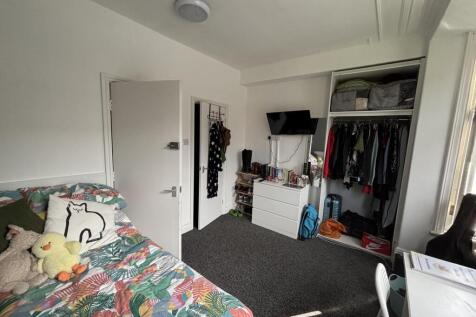 A cozy bedroom featuring a bed with a colorful ...