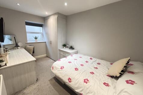 A clean and well-lit bedroom featuring a double...