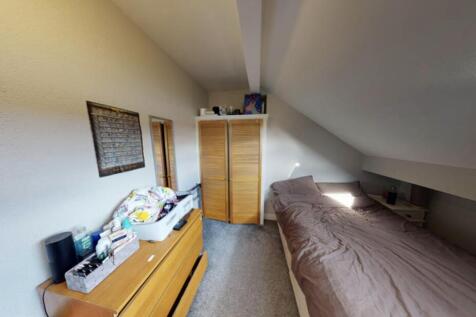 A cozy single bedroom featuring a neatly made b...