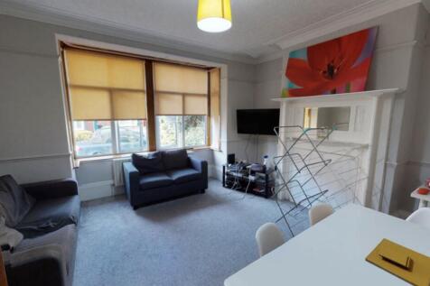 A spacious and well-lit living room featuring m...