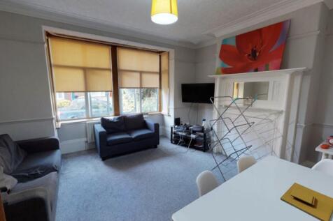 A spacious, well-lit living area featuring comf...