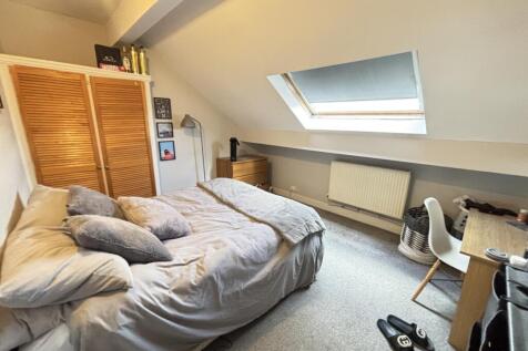 A cozy bedroom featuring a double bed with neat...