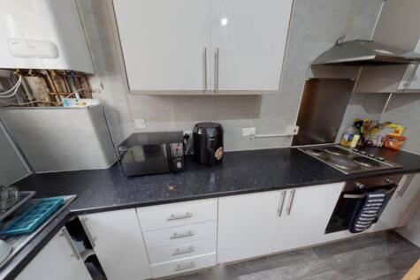 A modern kitchen area featuring a sleek black c...