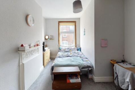 A cozy single bedroom with a neat bed, natural ...