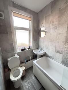 A modern, clean bathroom featuring a toilet, a ...