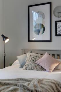 Bright, neatly styled bedroom with a comfortabl...