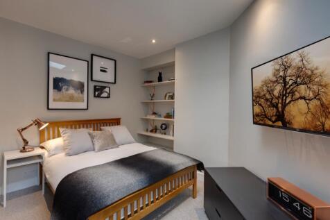 Contemporary double bedroom with a wooden slatt...