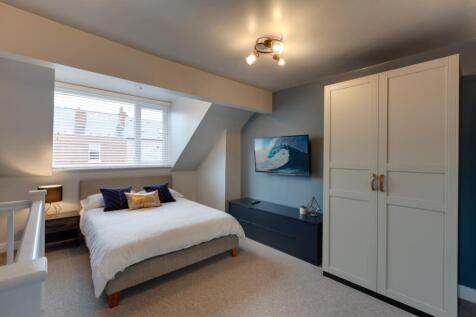 Bright, stylish attic master bedroom with a com...
