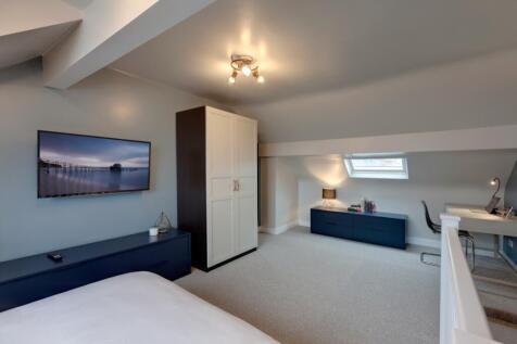 Bright, modern attic master bedroom with sloped...