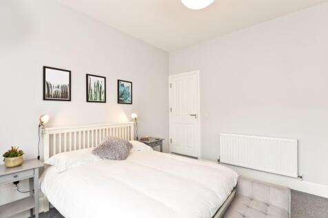 Bright, modern double bedroom with a white slat...