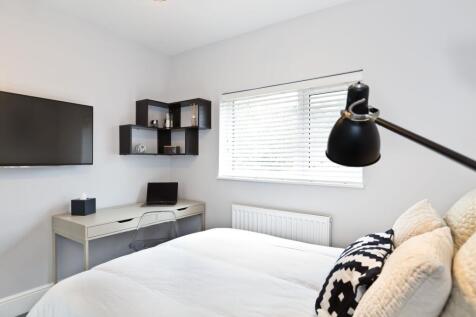 Bright, modern bedroom with a neatly made doubl...