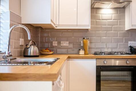Modern kitchen with white cabinetry, a wooden c...