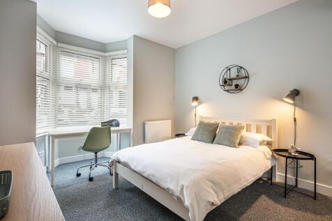 Bright and modern bedroom featuring a comfortab...