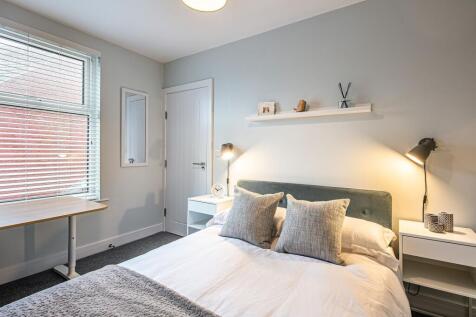 A bright and tidy bedroom featuring a double be...