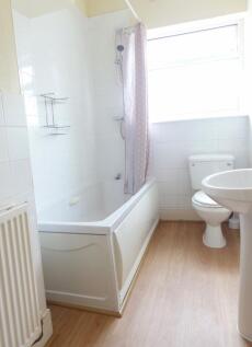 Bright, well-maintained bathroom with a white b...