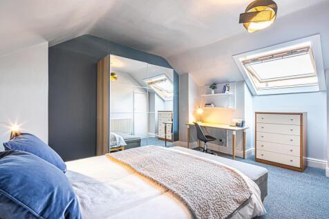 Bright and spacious master bedroom with large b...