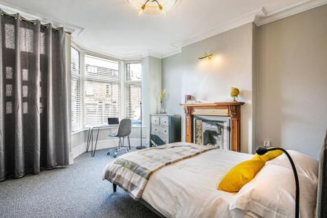 Bright and spacious bedroom featuring a large b...