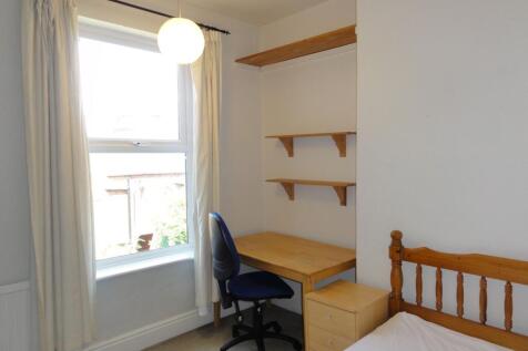 Bright, well-kept bedroom with a large window, ...