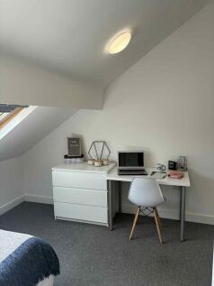 Bright, neatly presented bedroom corner with a ...