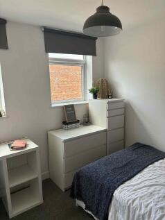 Bright, neatly styled bedroom with a comfortabl...