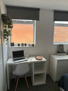 Bright, tidy bedroom corner featuring a clean w...