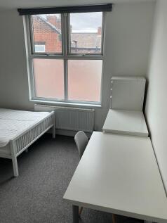 Bright, simply furnished bedroom with a large w...
