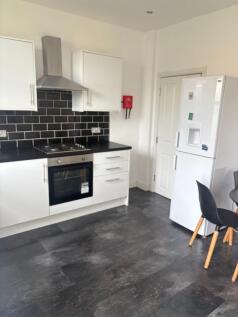 Bright modern kitchen with white cabinets, blac...