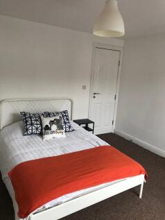 Bright, simply furnished bedroom with a white m...