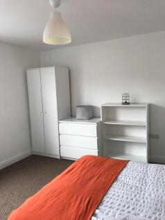 Bright, simply furnished bedroom with a double ...