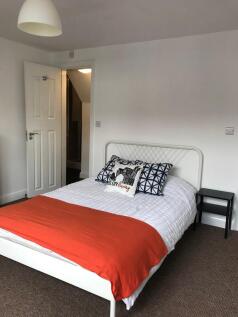 Bright, simply styled bedroom with a double met...