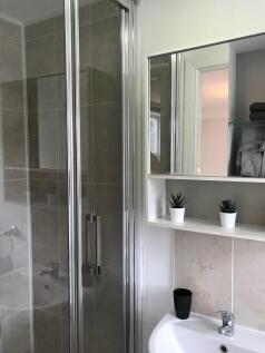Modern tiled bathroom with a corner shower cubi...