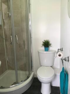 Bright, well-maintained bathroom with a curved ...