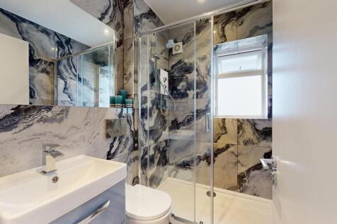 Stylish modern bathroom with a glass-enclosed s...
